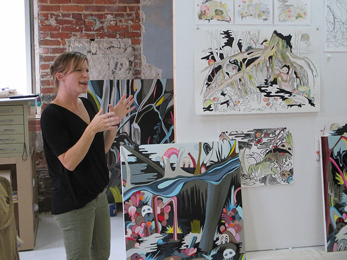 Sarah Emerson speaking in front of her work