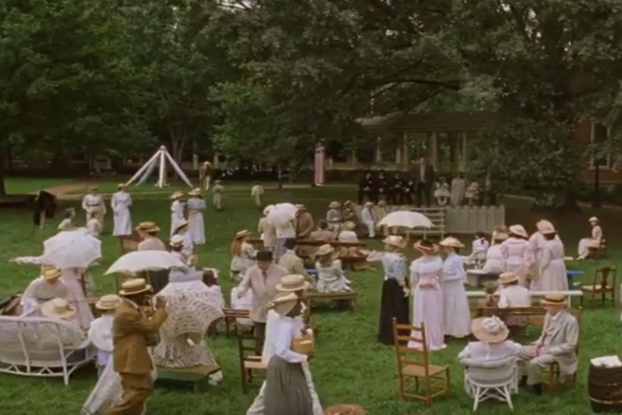 people dressed in old fashion clothes sitting on the quad 