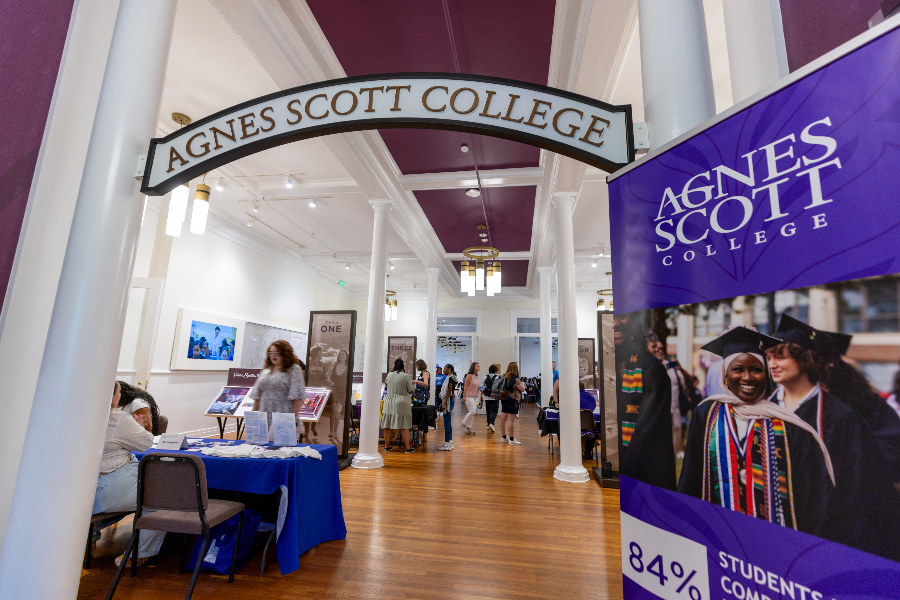 Students check in at tables around a common area. A branded arch reads Agnes Scott College