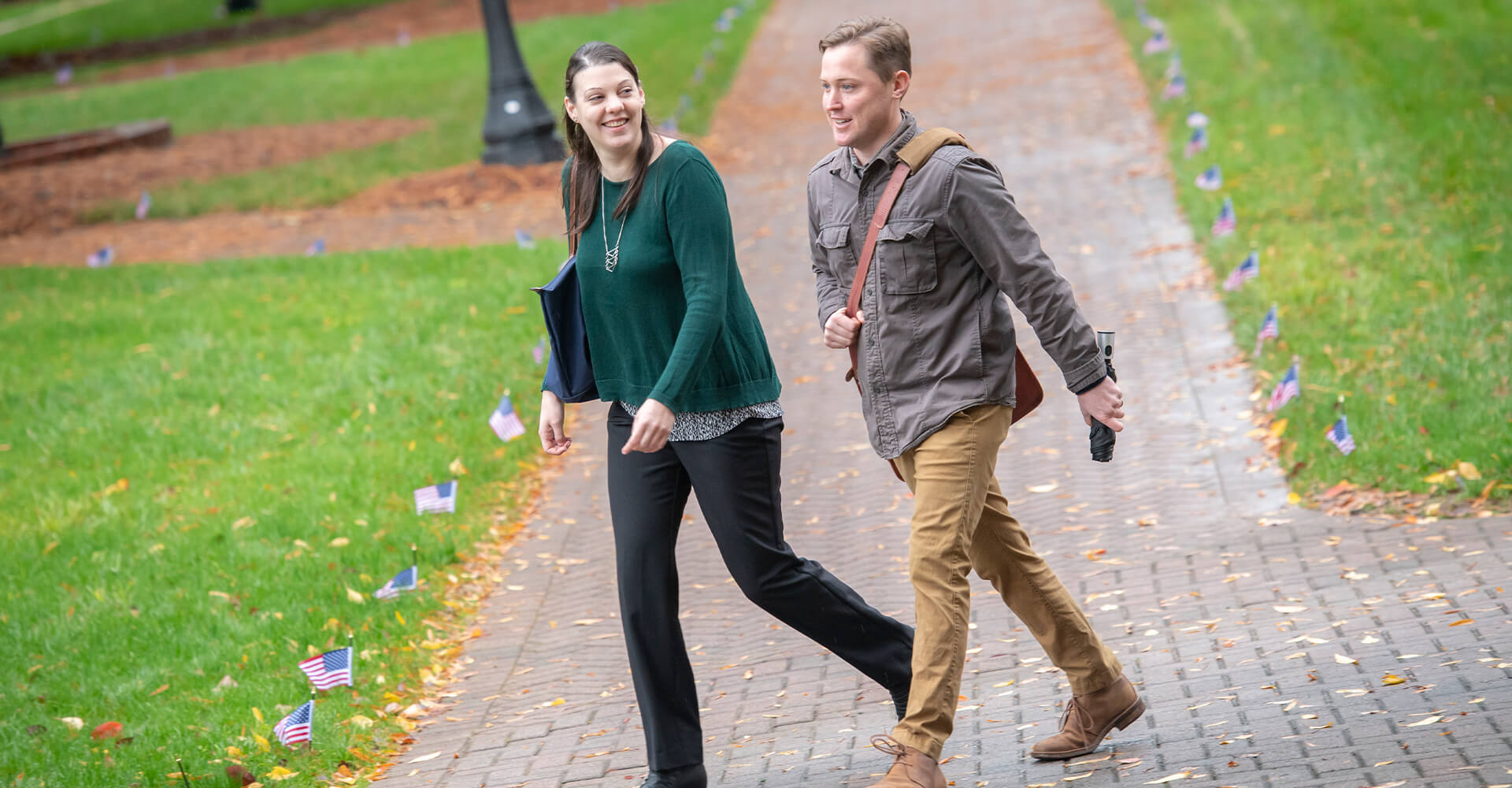 a woman and a man walking on campus