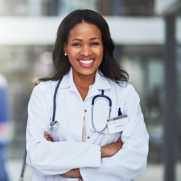 A smiling female medical professional standing in a hallway