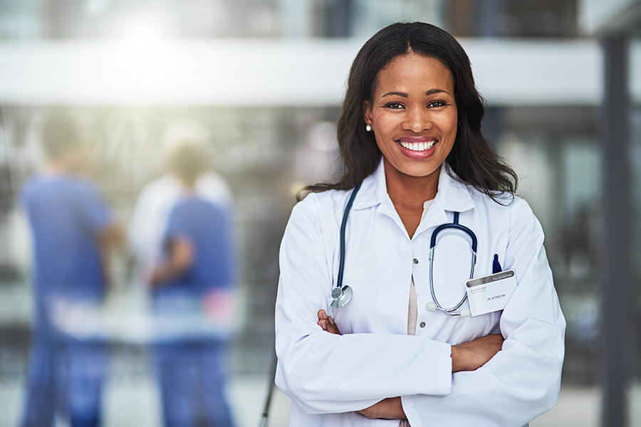 Student smiling in a white lab coat.