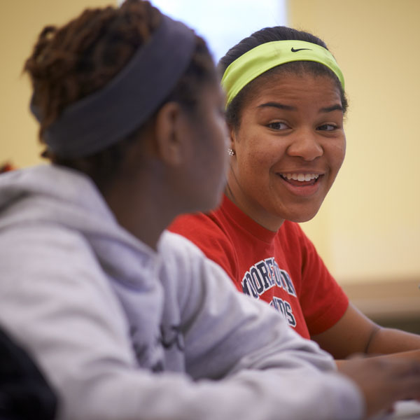 Two students smiling at each other.