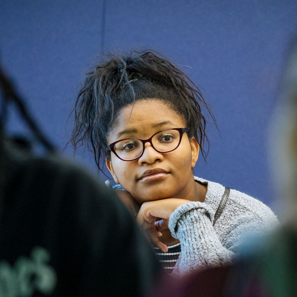 An Agnes Scott student wearing glasses in the mathematics and economics program listens in class.