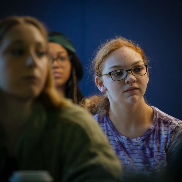 French major students look ahead and listen while sitting in class.