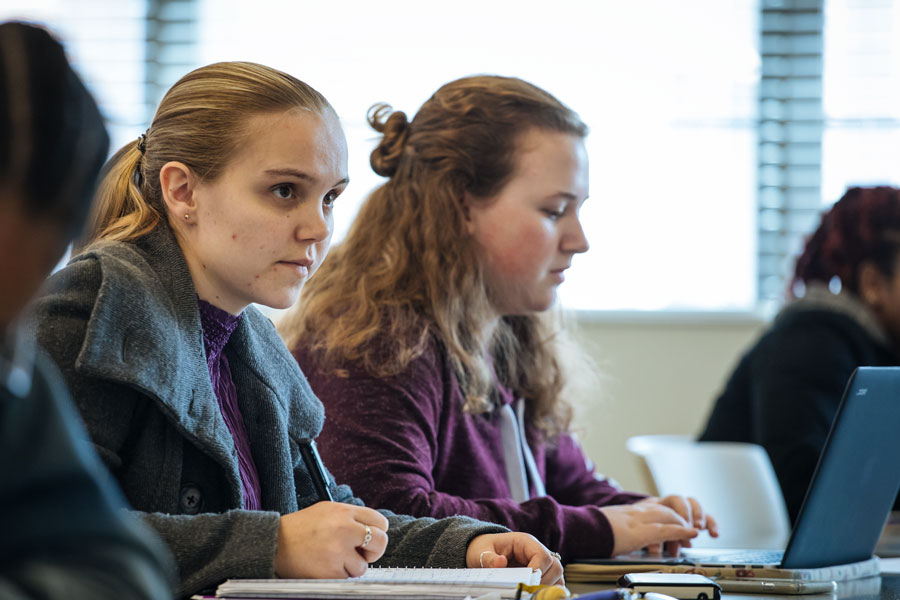 Group of students taking notes in class.