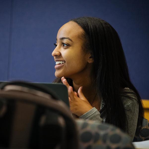 Asian studies student listening and smiling in class.