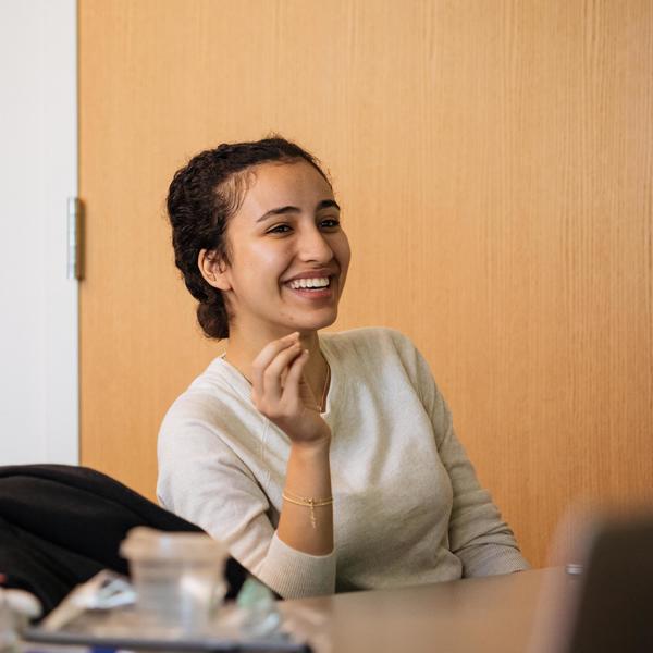 An Agnes Scott religious and social justice major smiles while sitting in class.