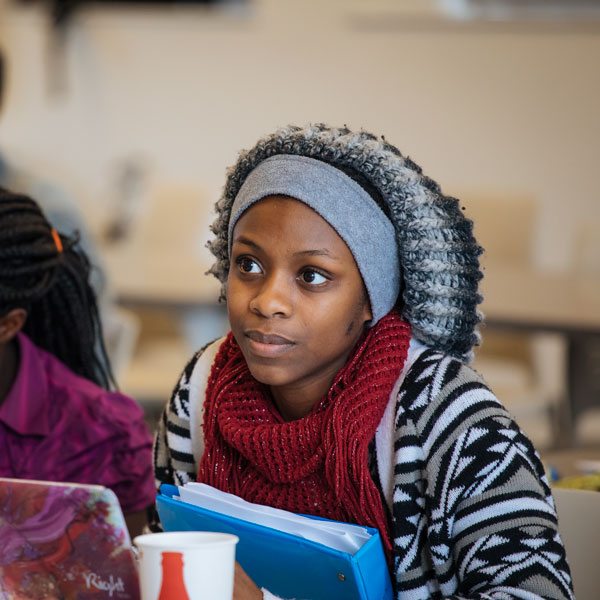 A history major student leans forward and listens in class.