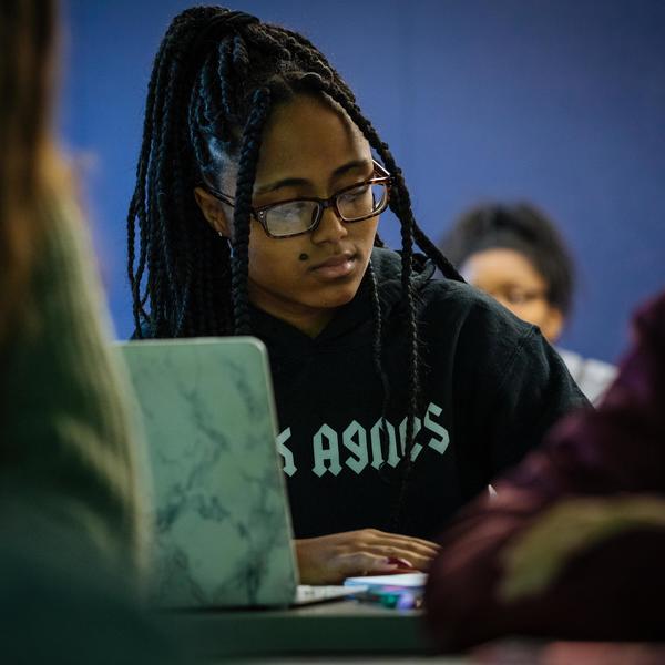 A classical civilizations major student takes notes in class.