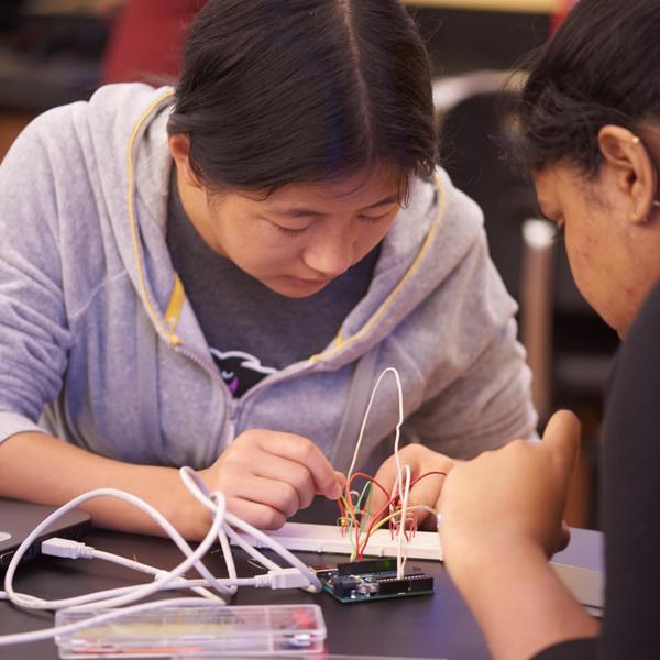 An engineering major student wiring a circuit board.