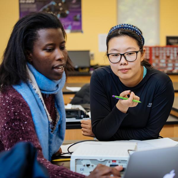 Two Agnes Scott College students talking in an artificial intelligence class.