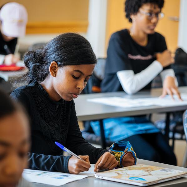 A classical languages major student, looks down at her paper while taking notes.