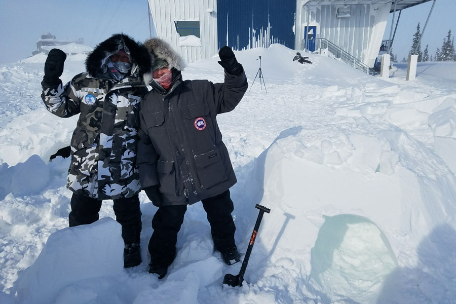 Two Agnes Scott study abroad co-leaders waving in a blizzard in Manitoba, Canada in 2017.