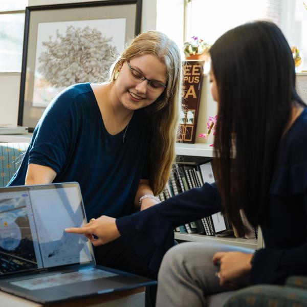 Two psychology major students reviewing images of brain scans on a laptop.