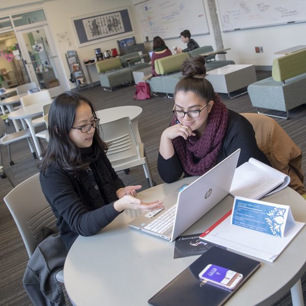 Two students consider a laptop