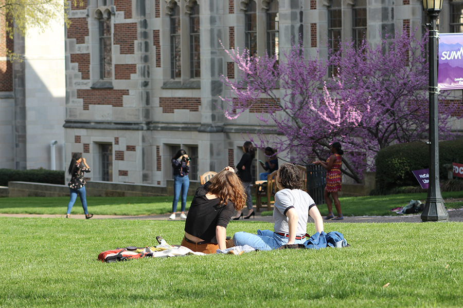 Two students on picnic blanket on front quad.