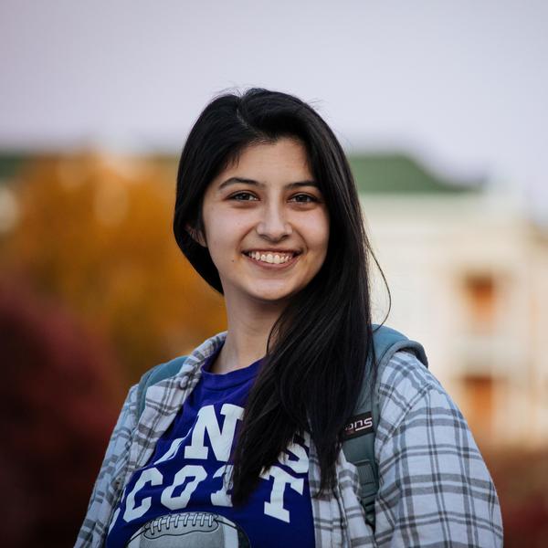 Student with dark hair smiles at camera.