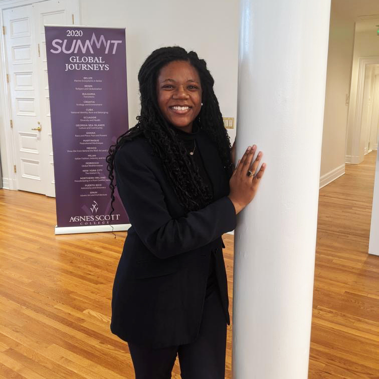 photo of smiling girl with SUMMIT banner in background