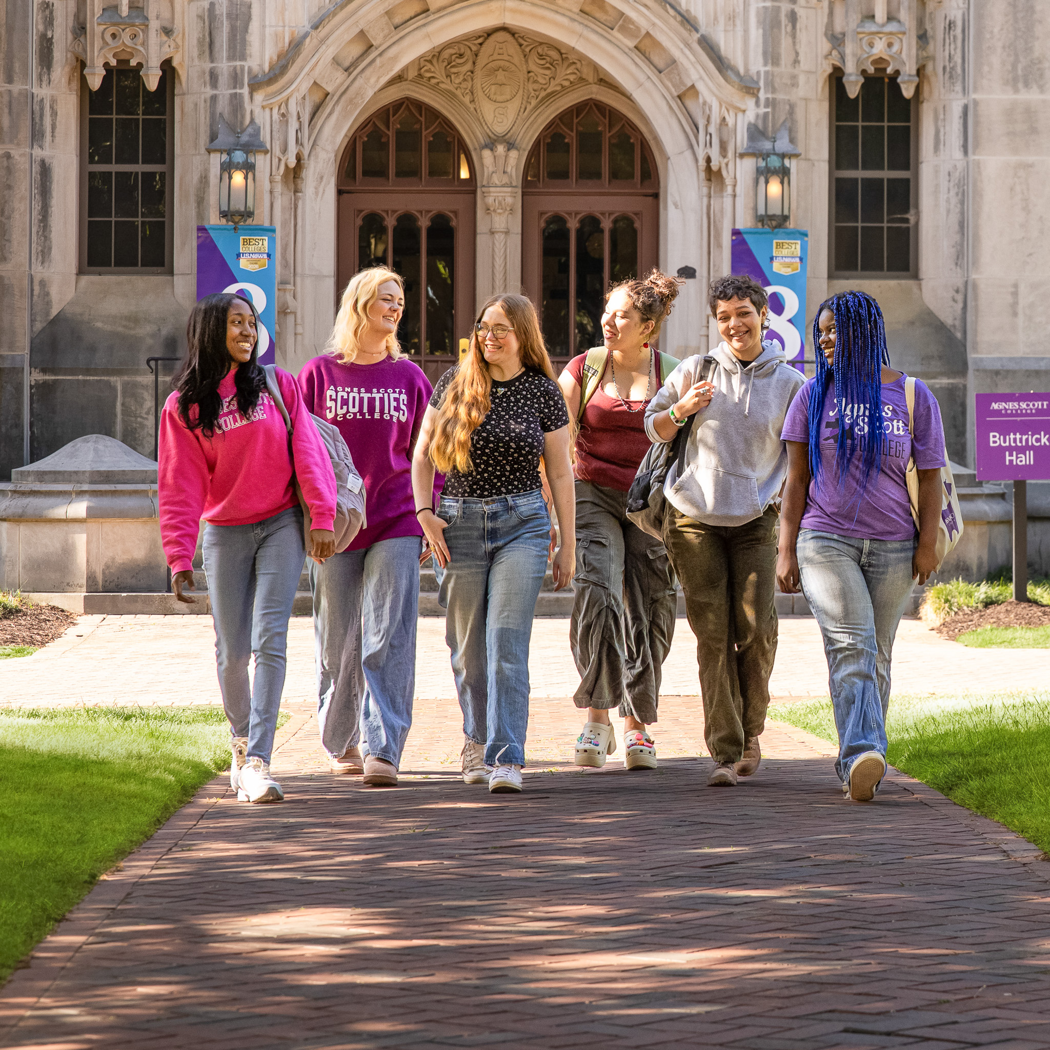 Agnes Scott students sitting on a lawn and talking