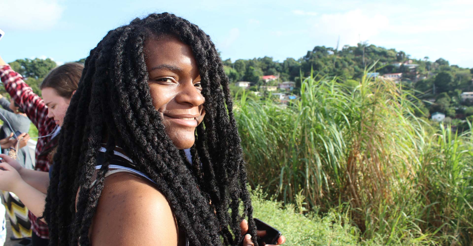 A student poses for a photo in front of hilly fields.