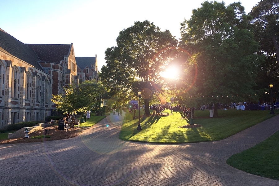 The evening pokes through the trees in front of Buttrick Hall.
