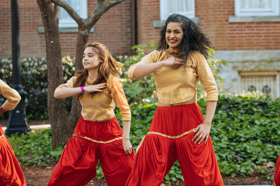 A student bollywood dance team performs outside.