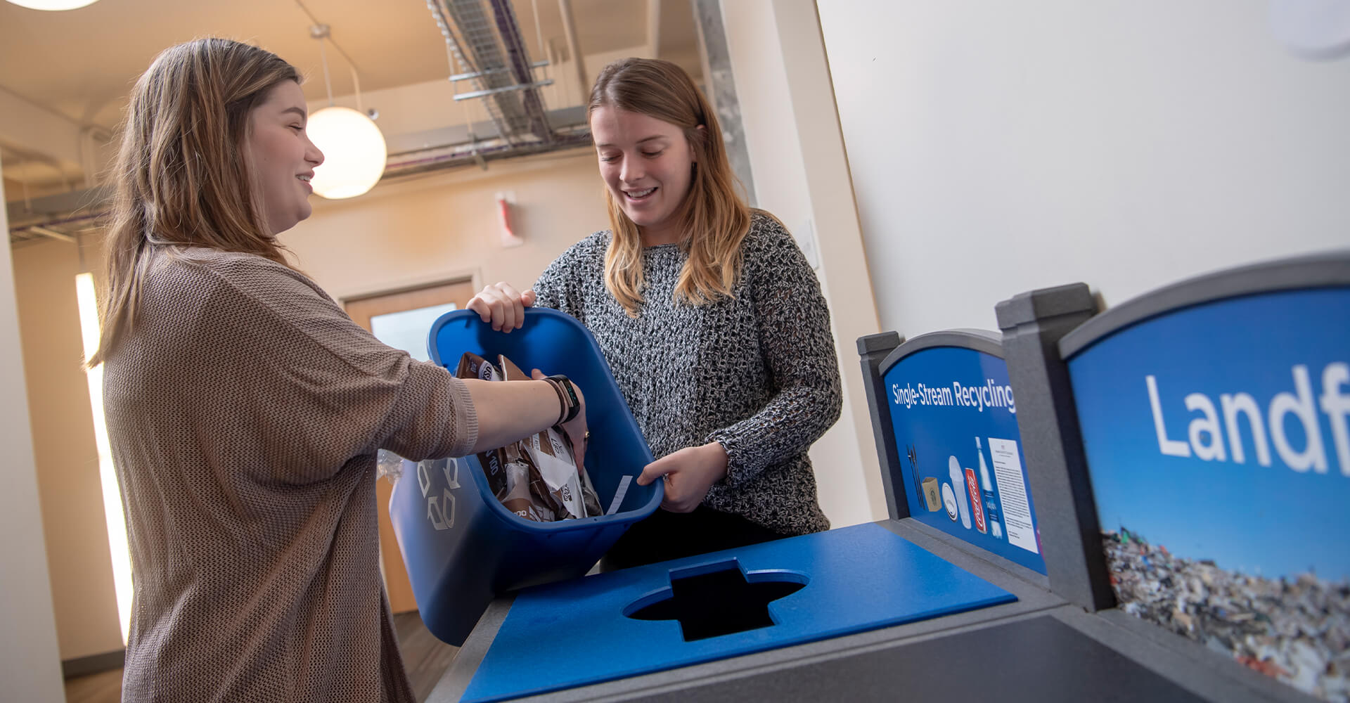 two students recycling paper