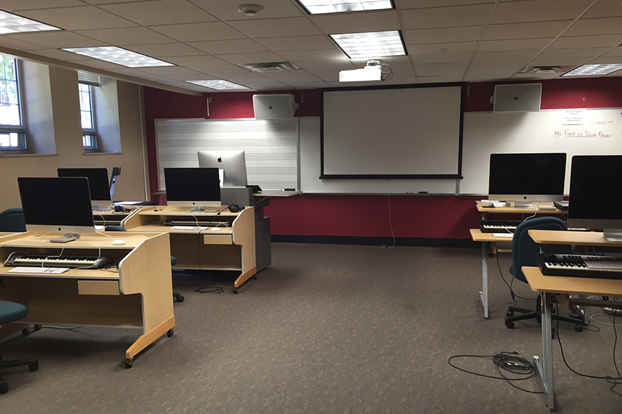 View of Presser G19 with Apple computers, musical keyboards, projection screen, and whiteboard with musical staff