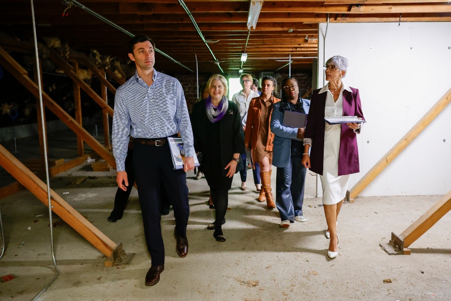 a group of people walk through a construction zone inside a building while talking to each other
