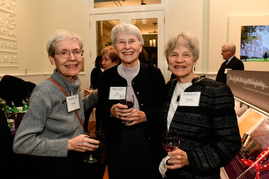 A group of women stand together for a photo with name badges.