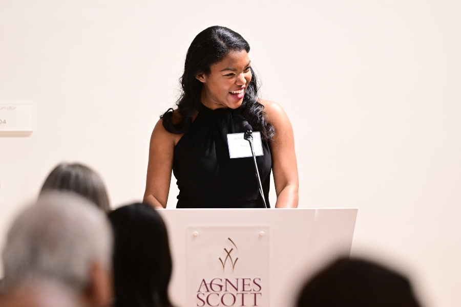 A woman smiles at a podium