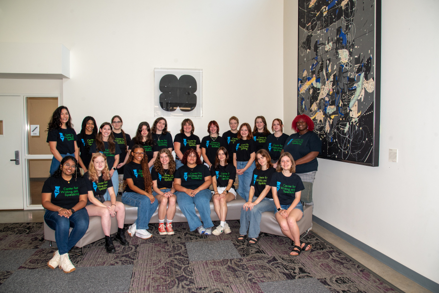 a group of student tutors gather wearing the same branded black tee shirts