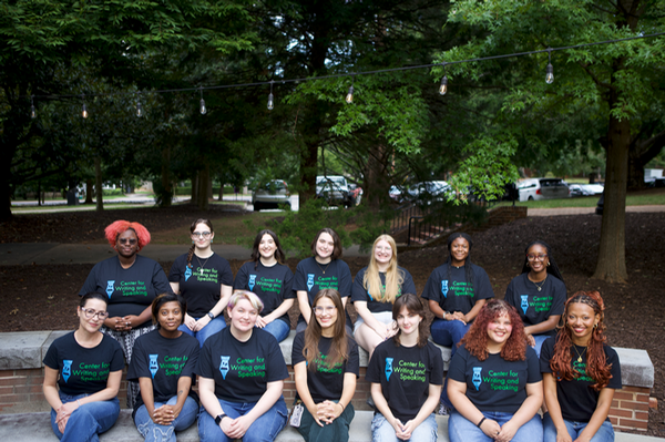 a group of student tutors gather wearing the same branded black tee shirts