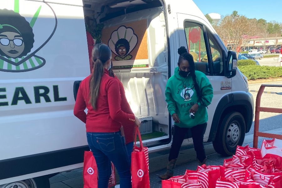 Crystal Perry and a Target employee load her white van for her non-profit Melanated Pearl. 