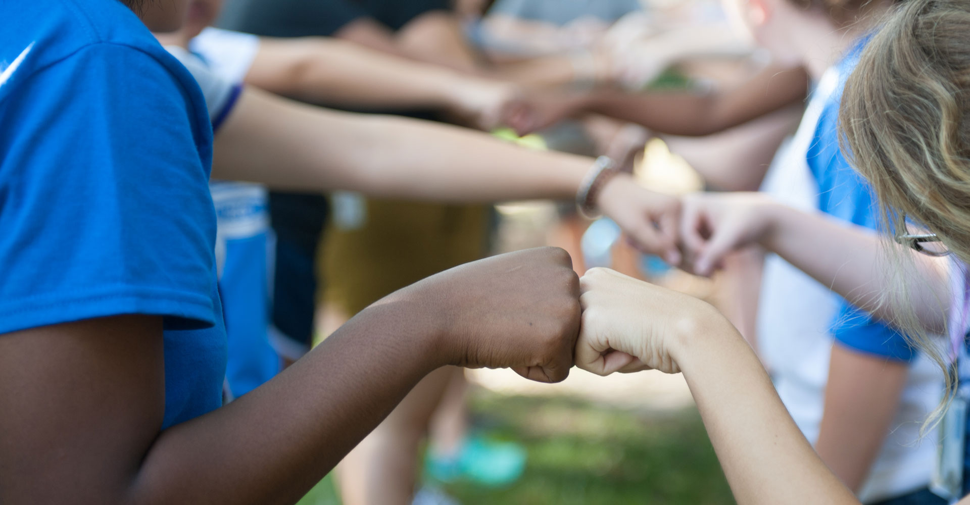 Agnes Scott Summit students give each other fist bumps.