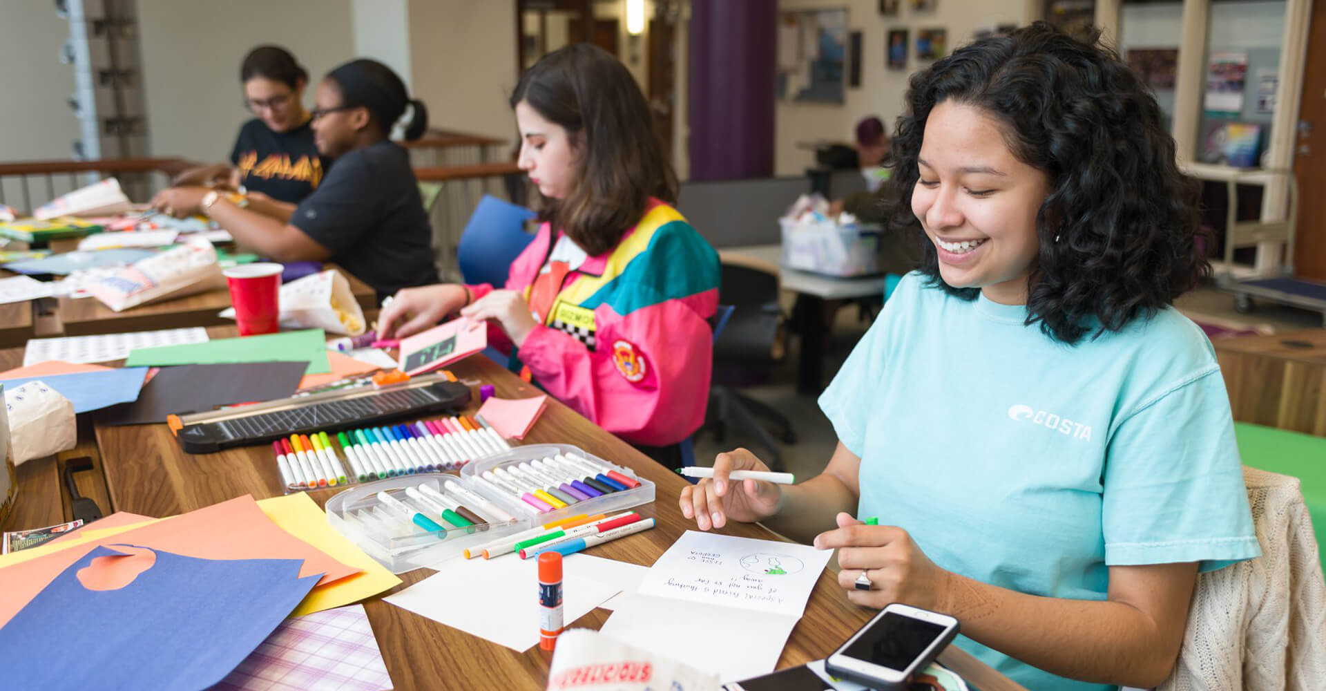 four students working on cards at a table